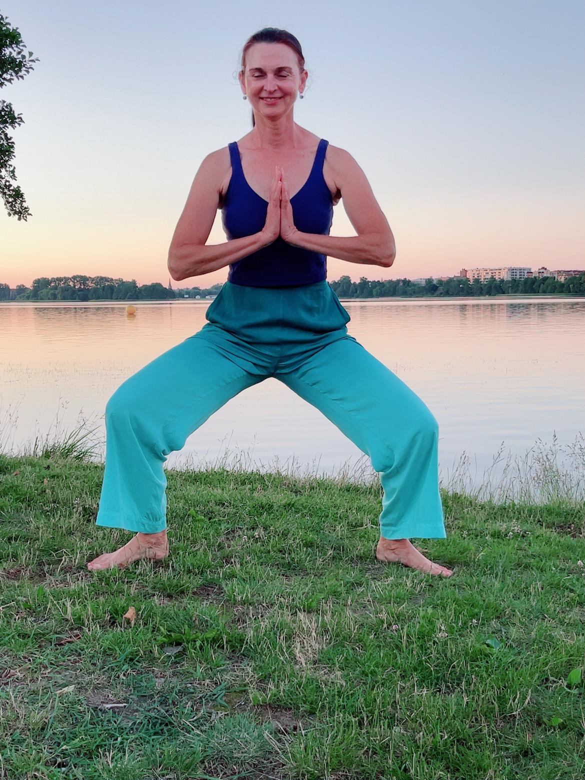 Urszula practicing yoga beside a lake